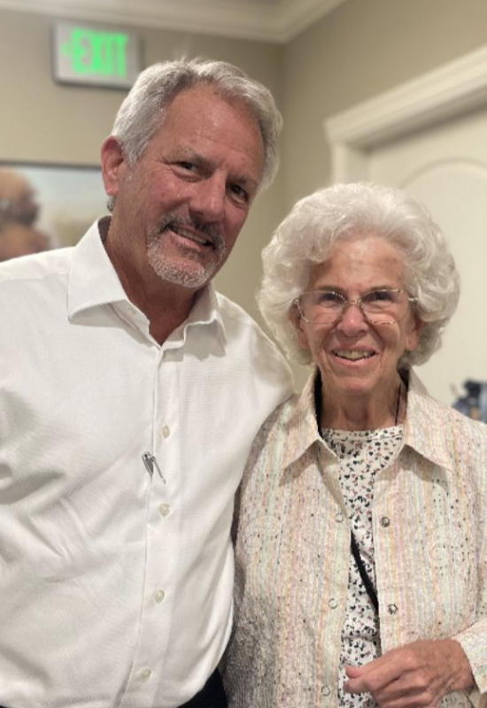 Founder Chuck Eusey standing with a smiling senior resident.
